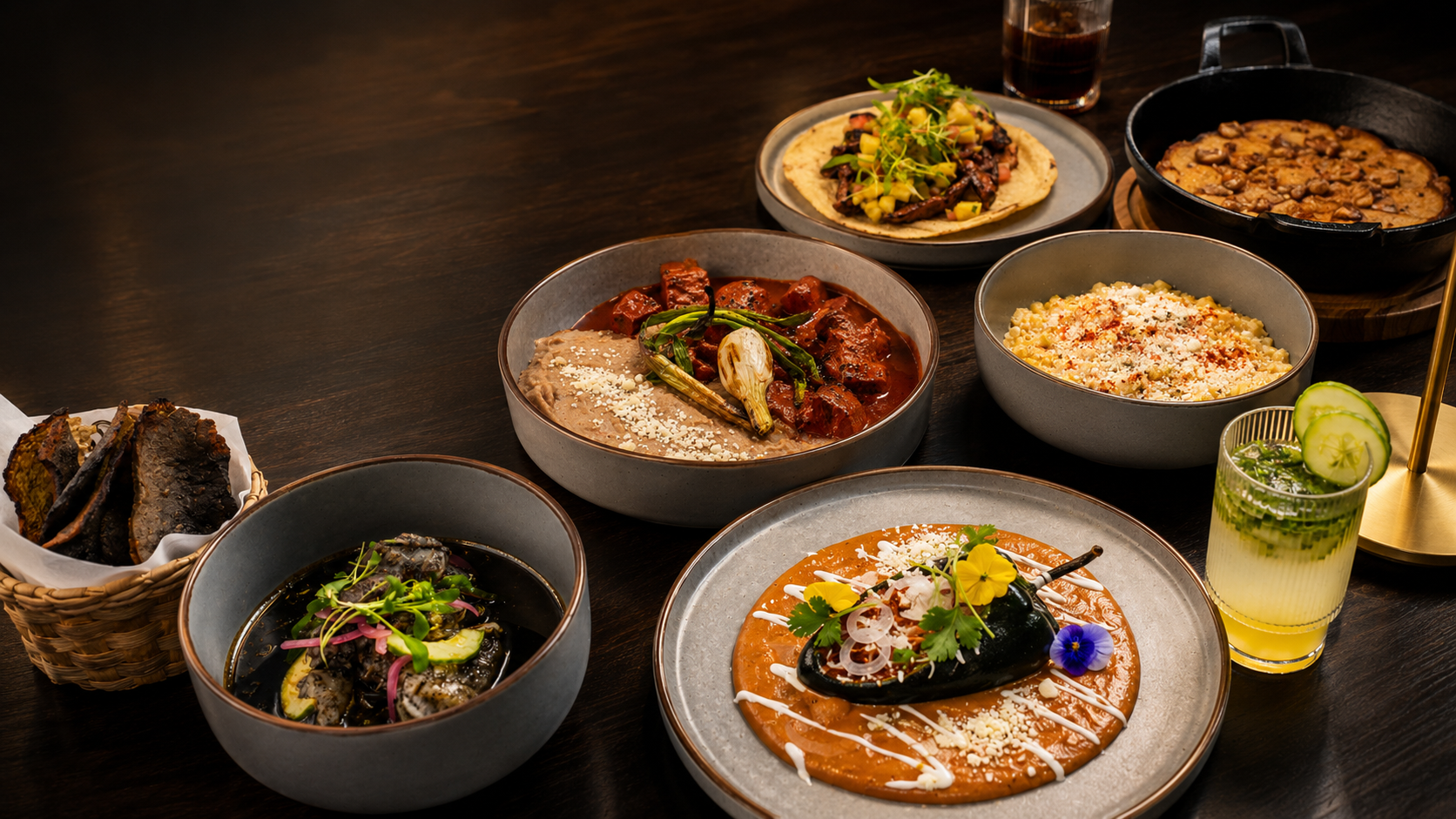 A shared Mexican table with tortillas, chiles, and cocktails